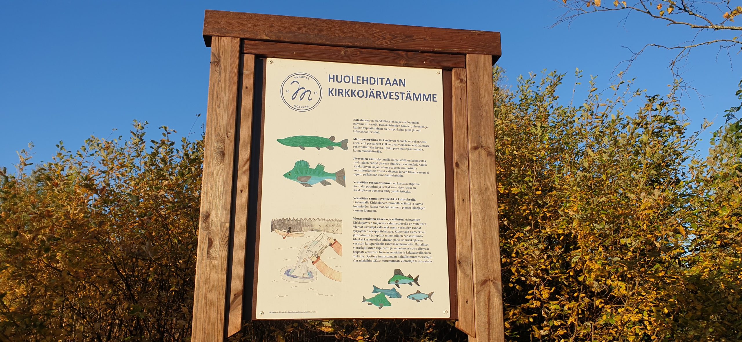 Kuvassa on Myrskylän Kirkkojärven rannalla oleva kyltti "Huolehditaan Kirkkojärvestämme"